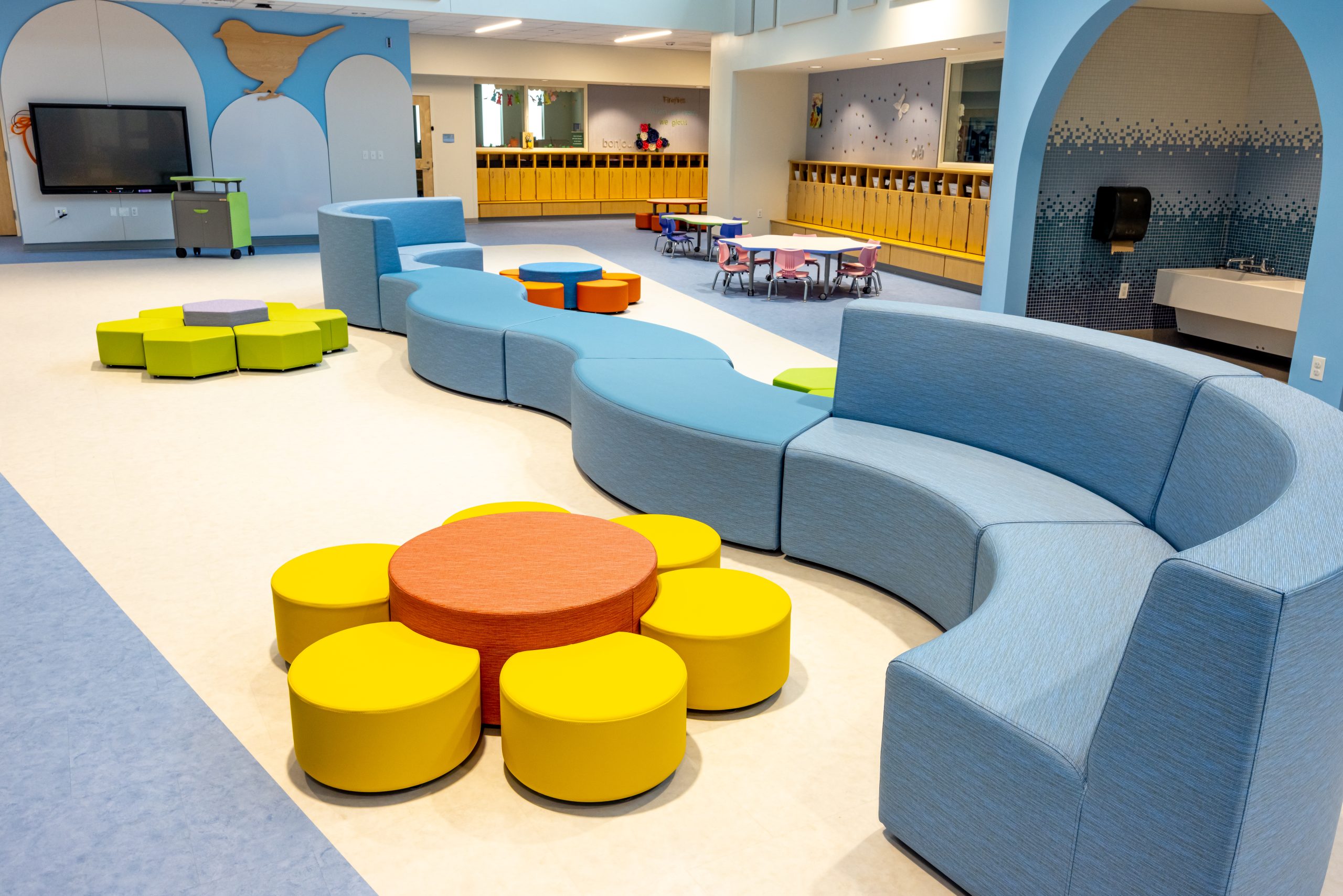 interior of a preschool play area with colorful modular furniture and small tables and chairs