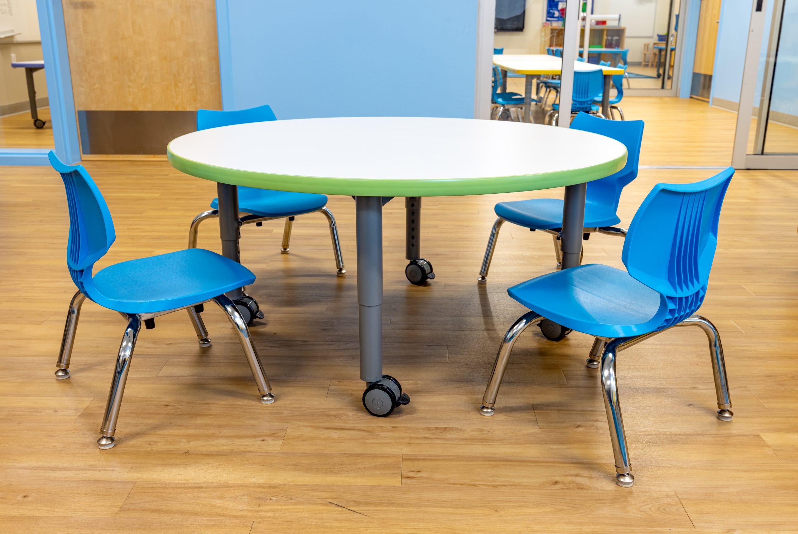 a child sized circular table with 4 blue chairs
